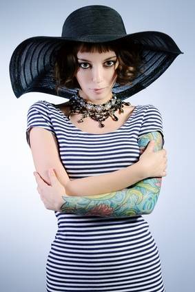 Frau mit Tattoos und Hut